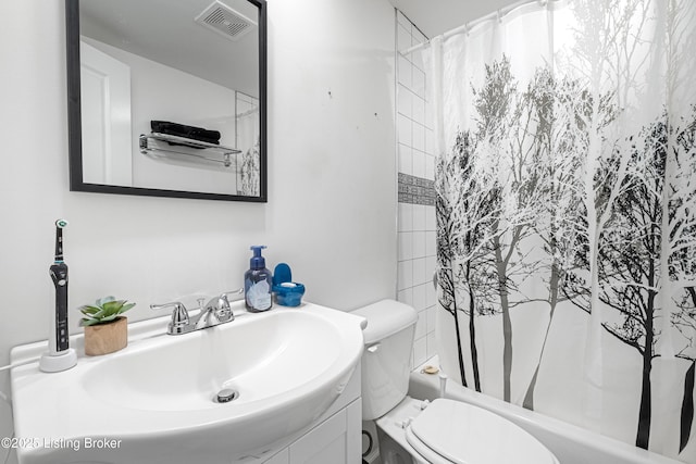 full bathroom featuring shower / bath combo, vanity, and toilet