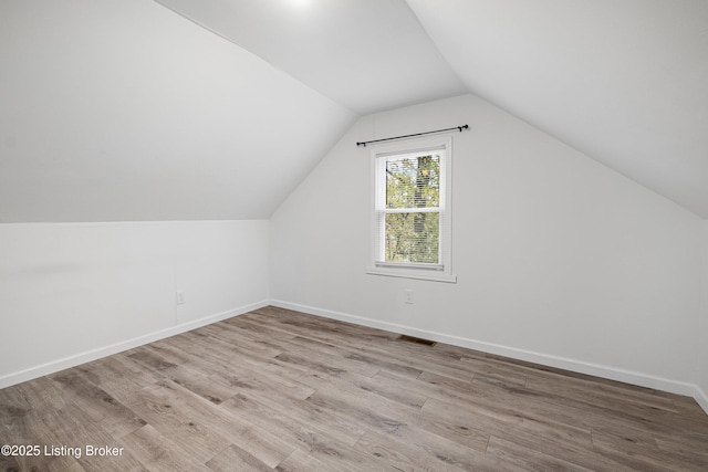 bonus room featuring lofted ceiling and light hardwood / wood-style flooring