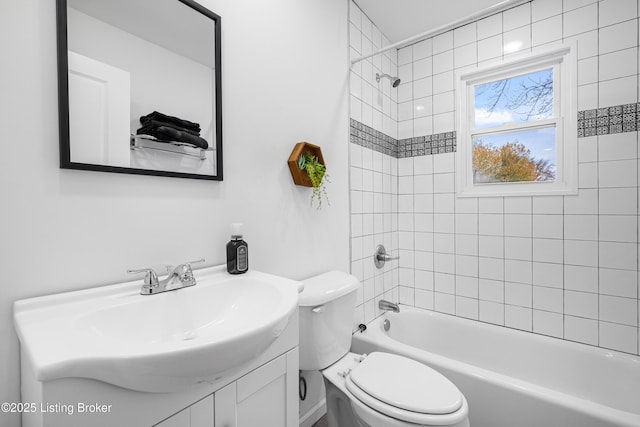 full bathroom featuring vanity, tiled shower / bath, and toilet