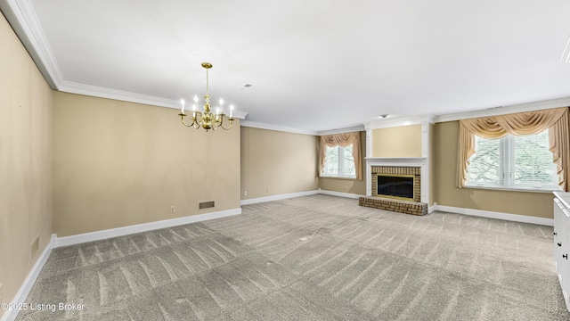 unfurnished living room featuring ornamental molding, a brick fireplace, carpet flooring, and a chandelier