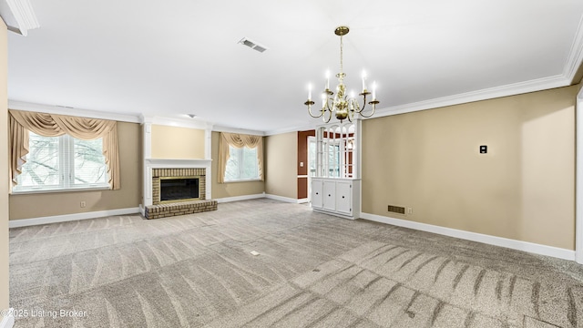 unfurnished living room featuring crown molding, carpet flooring, a brick fireplace, and a notable chandelier