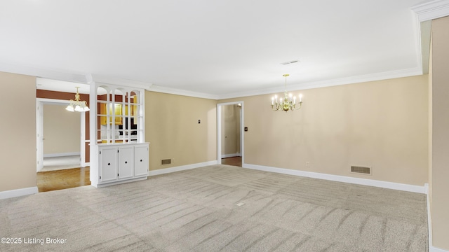 unfurnished room with light colored carpet, ornamental molding, and a chandelier