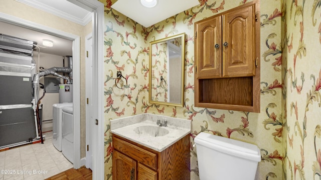 bathroom featuring heating unit, vanity, independent washer and dryer, toilet, and crown molding