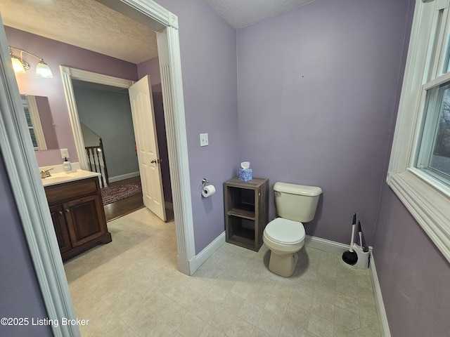 bathroom featuring vanity, a textured ceiling, and toilet