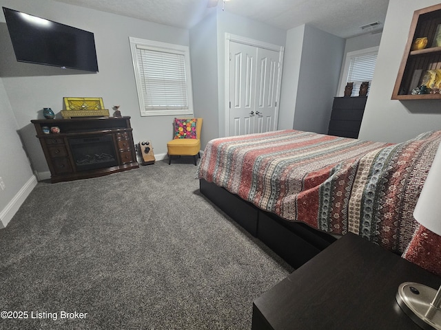 carpeted bedroom with a closet and a textured ceiling