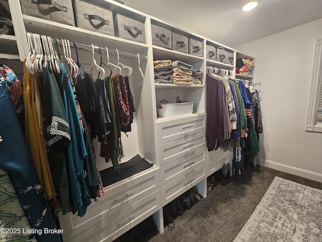 spacious closet featuring dark colored carpet