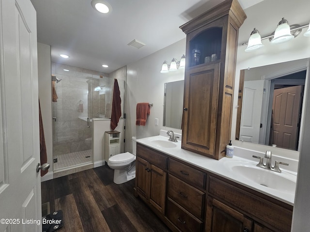 bathroom with wood-type flooring, toilet, an enclosed shower, and vanity