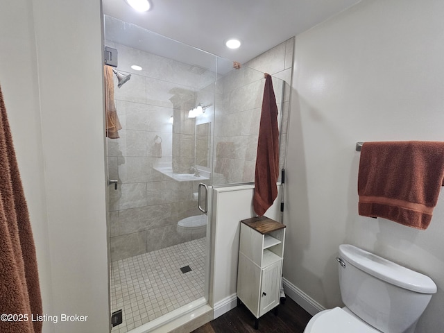 bathroom with hardwood / wood-style floors, toilet, and walk in shower