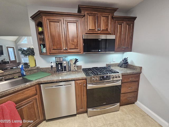 kitchen with appliances with stainless steel finishes, sink, and light tile patterned floors