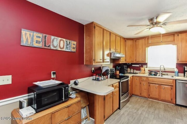 kitchen featuring sink, light hardwood / wood-style flooring, ceiling fan, and appliances with stainless steel finishes