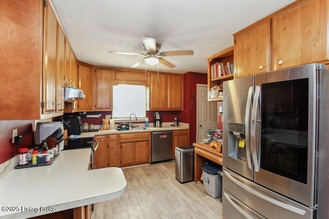 kitchen with ceiling fan, appliances with stainless steel finishes, sink, and light hardwood / wood-style flooring