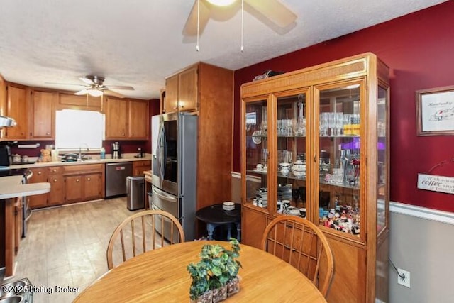 dining area featuring sink, ceiling fan, and light hardwood / wood-style flooring