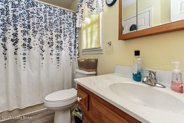 bathroom with vanity, curtained shower, toilet, and hardwood / wood-style flooring