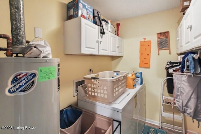 clothes washing area featuring cabinets, separate washer and dryer, and water heater