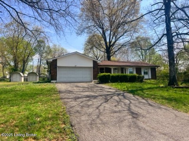 single story home featuring a garage, driveway, and a front lawn