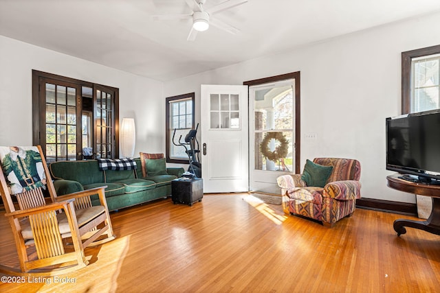 living room featuring ceiling fan, wood-type flooring, and plenty of natural light