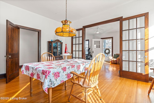 dining area with french doors and light hardwood / wood-style flooring