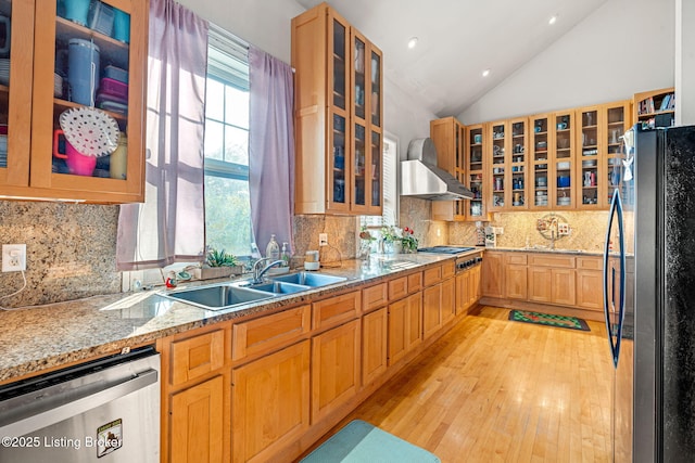 kitchen featuring light stone counters, sink, stainless steel appliances, and lofted ceiling