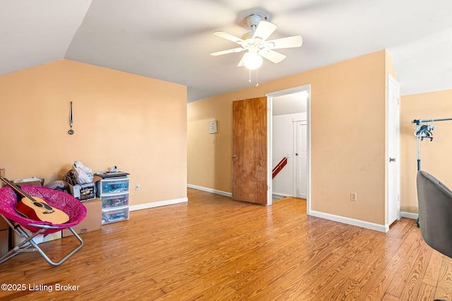 living area featuring ceiling fan, lofted ceiling, and light hardwood / wood-style flooring