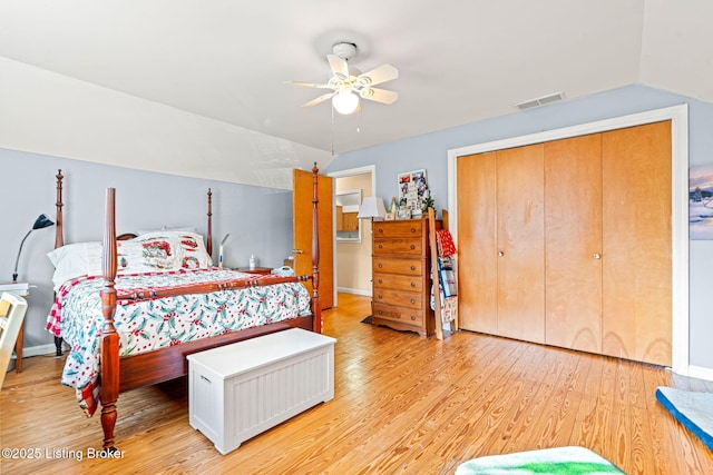 bedroom with lofted ceiling, light hardwood / wood-style flooring, a closet, and ceiling fan