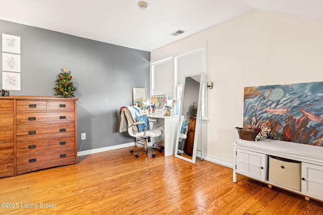 home office with vaulted ceiling and light hardwood / wood-style floors