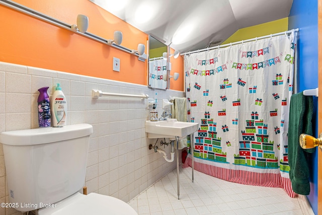 bathroom with tile walls, tile patterned floors, toilet, and a shower with shower curtain