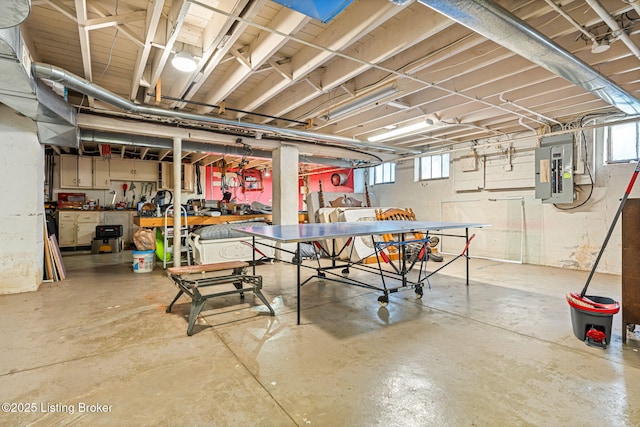 basement with electric panel and a workshop area