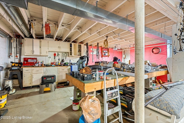 miscellaneous room featuring concrete flooring and a workshop area