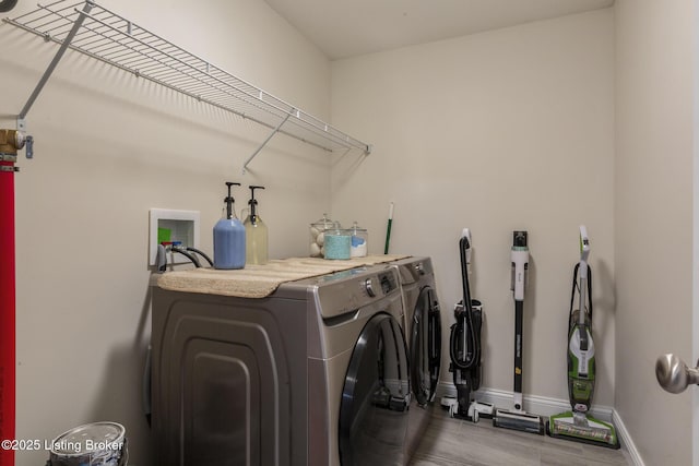 clothes washing area with wood-type flooring and washing machine and clothes dryer