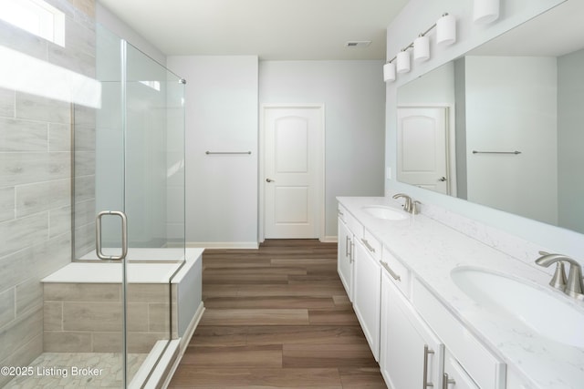 bathroom with an enclosed shower, vanity, and hardwood / wood-style flooring