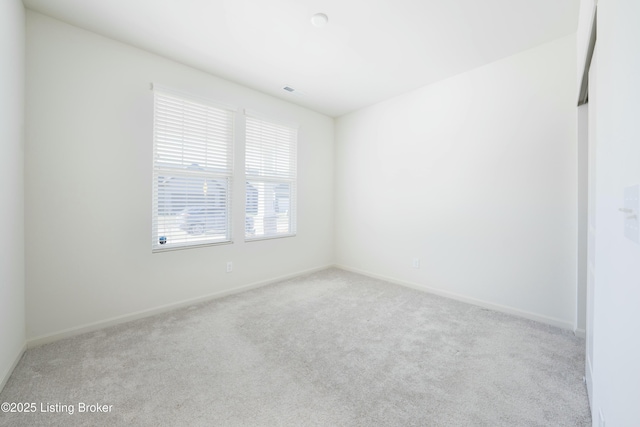 empty room featuring visible vents, baseboards, and carpet flooring