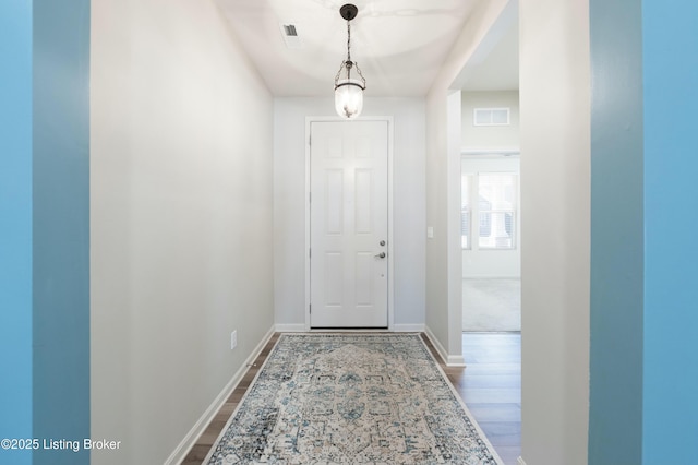 entryway featuring visible vents, baseboards, and dark wood-style floors