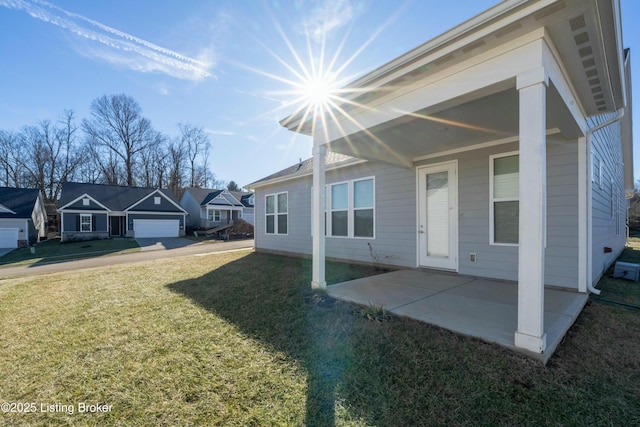 view of front facade featuring a garage, a front lawn, and a patio