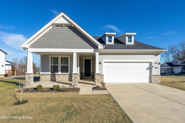 craftsman inspired home with an attached garage, covered porch, concrete driveway, a front lawn, and stone siding