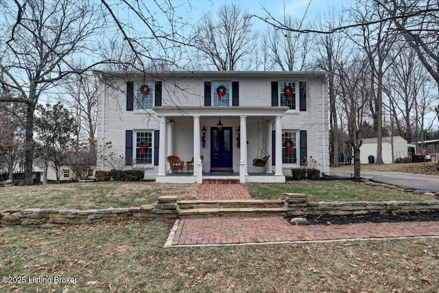 view of front of home featuring covered porch and a front lawn