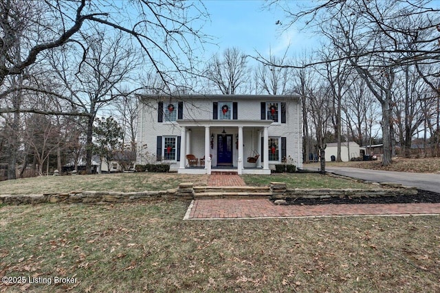 view of front of home with a porch and a front yard