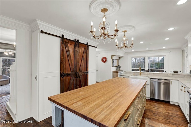 kitchen with hanging light fixtures, a center island, white cabinets, wood counters, and stainless steel dishwasher