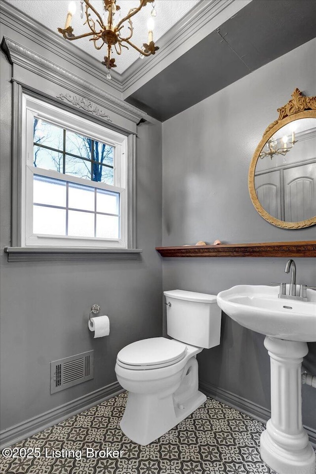 bathroom featuring tile patterned floors, toilet, and a chandelier