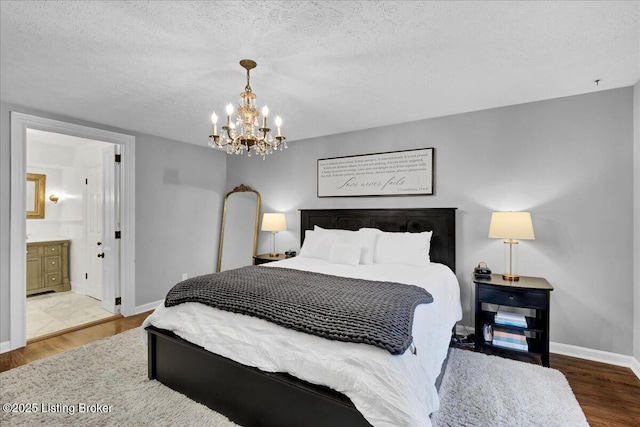 bedroom with ensuite bathroom, hardwood / wood-style floors, and a textured ceiling