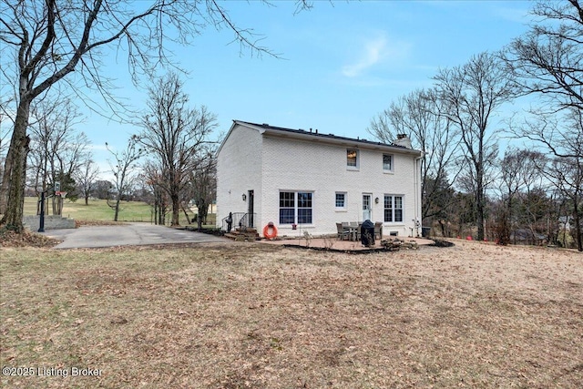 rear view of property featuring a yard and a patio area