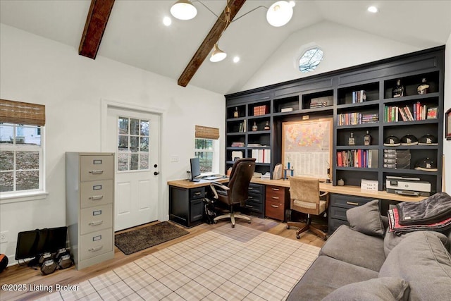 home office with light hardwood / wood-style flooring and lofted ceiling with beams