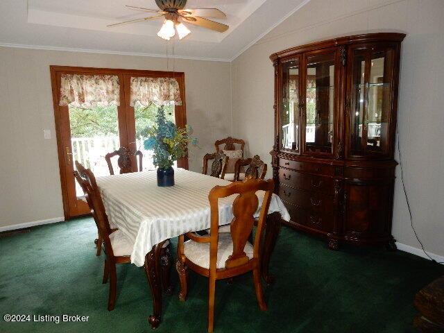 dining room with carpet floors, ornamental molding, ceiling fan, and vaulted ceiling