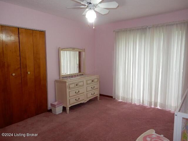 carpeted bedroom with ceiling fan and a closet