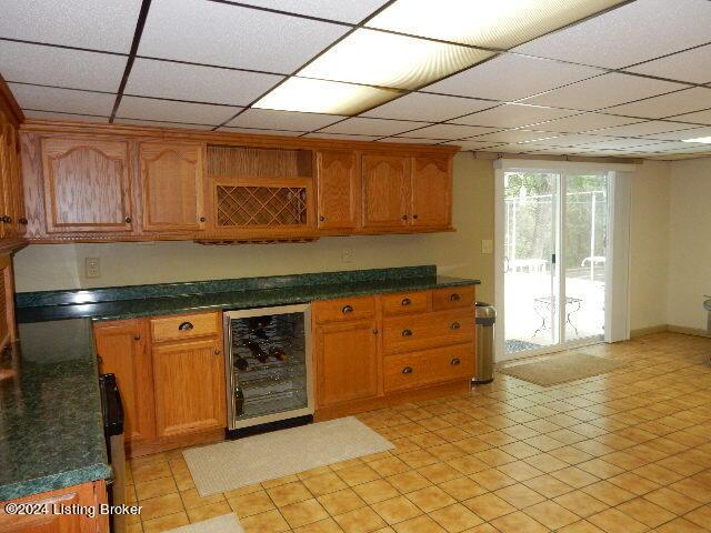 kitchen featuring beverage cooler and a drop ceiling