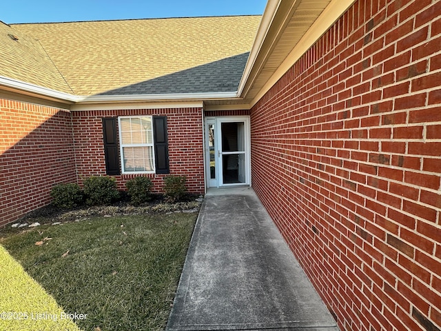 view of exterior entry with a lawn