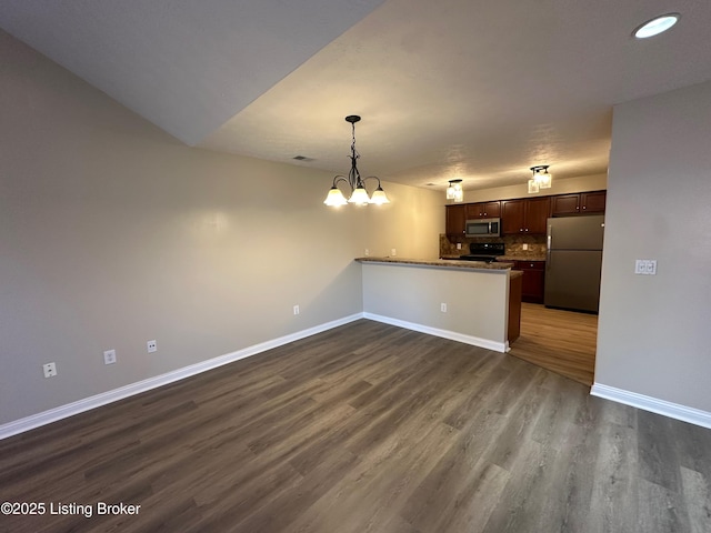 kitchen featuring appliances with stainless steel finishes, dark hardwood / wood-style flooring, kitchen peninsula, and a notable chandelier