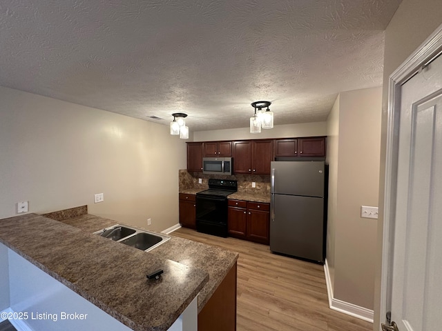 kitchen featuring sink, tasteful backsplash, kitchen peninsula, stainless steel appliances, and light hardwood / wood-style floors