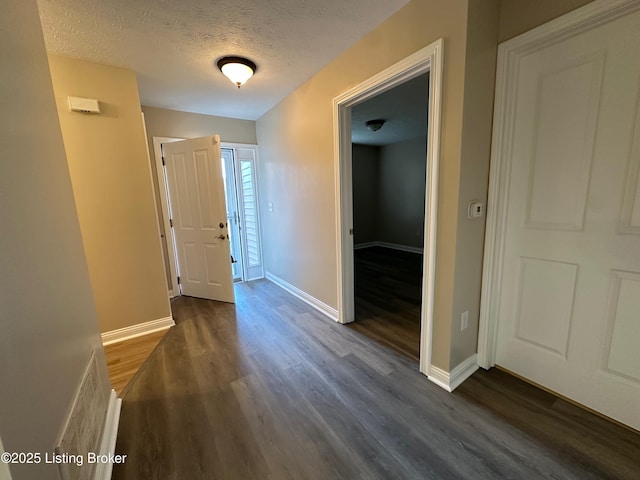 hall featuring dark hardwood / wood-style flooring and a textured ceiling