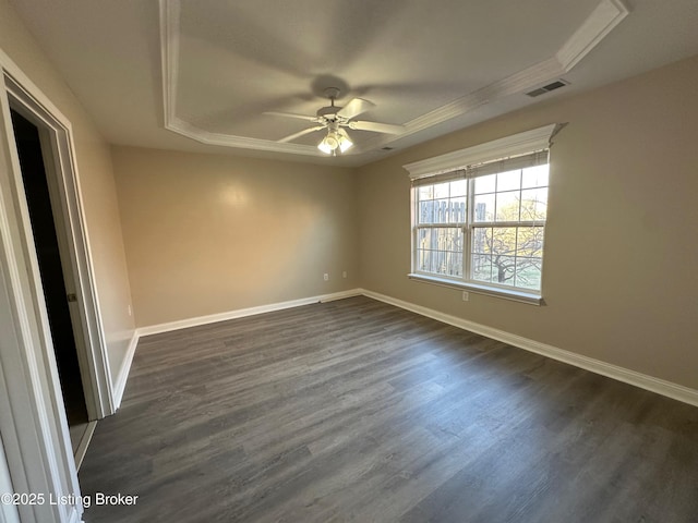 unfurnished room with a tray ceiling, dark hardwood / wood-style floors, and ceiling fan