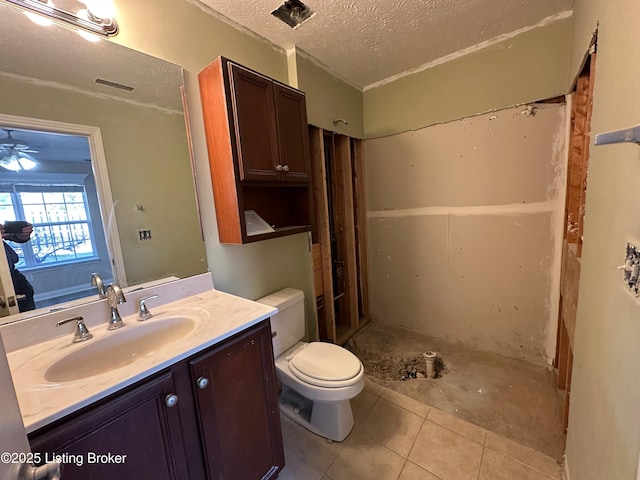 bathroom with a shower, vanity, toilet, tile patterned floors, and a textured ceiling